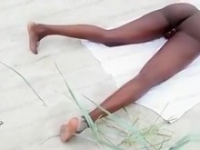 Chica de ébano se masturba en la arena mientras es filmada