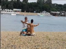 Milf Lilly desnuda en la playa pública recibe un masaje con aceite de un extraño
