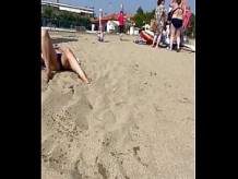 Esposa expone el coño debajo de las bragas en una playa pública