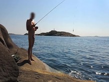 Pesca pública desnuda en la playa nudista