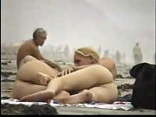 Pareja juega en la playa nudista