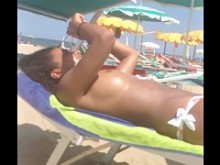 Adolescente de ébano en topless en la playa