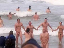Cientos de nudistas corriendo desnudos hacia el mar