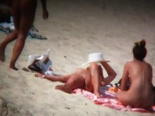 Madura rubia abriendo su coño afeitado en la playa