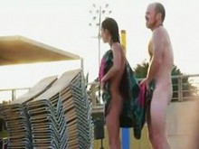 Atractivas personas desnudas en la playa nudista del lado de la calle se burlan entre sí
