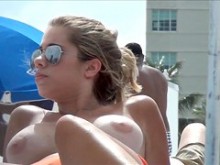 Chica de playa en topless con enormes tetas