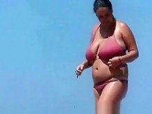 mujer con grandes pechos en la playa