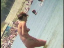 Video nudista en la playa tiene a una chica tímida jugando en el agua