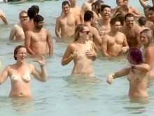 Enorme grupo de nudistas nadan en el océano