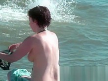 Sudoroso coño bronceado en la playa nudista