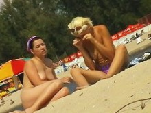Dos chicas en topless tomando el sol frente a una cámara oculta
