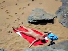 chica desnuda en la playa tomando el sol.