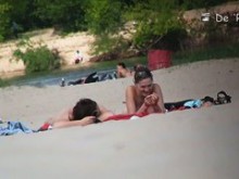 Video voyeur en la playa de una tímida chica en topless tomando el sol
