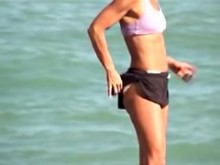 Chica deportiva en sujetador sexy y pantalones cortos sinceros en la playa 01m
