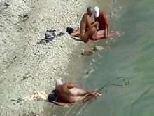 Dos parejas nudistas espiadas en una playa rocosa