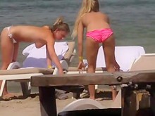 Chicas en topless relajándose en la playa