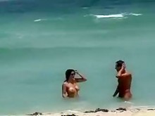 Milf caliente con grandes tetas obtiene su culo desnudo masajeado en la playa