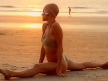 Belleza calva haciendo yoga junto al mar