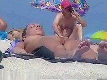 Cámara espía en una playa nudista con una pareja sexy enfocada