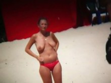 Mujer de grandes pechos conociendo a un maromo en la playa nudista