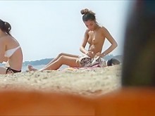 Tetas pequeñas bronceadas en topless en la playa
