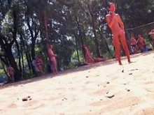 Valle desnudo en la playa nudista con chicas y adultos