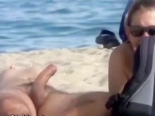 Esposa acaricia su pene medio duro en la playa