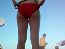 Mujer cambiándose en la playa bajo la falda