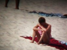 Chicas bronceadoras desnudas se exponen a una cámara espía en la playa