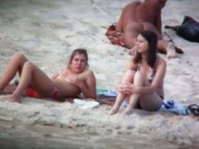 Voyeur espía en la playa captura a dos amigas tomando el sol en topless