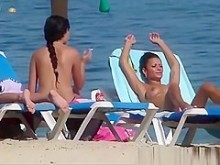 Chicas guapas en topless tomando el sol en la playa