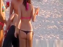 Una chica caliente en tanga en la playa