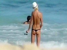 Chica flaca en topless entra al agua