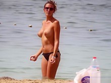 Morena de cuerpo caliente con tetas perfectas filmada en la playa en topless