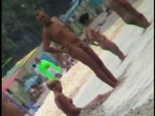 Voyeur vista de diversión en el agua en una playa nudista