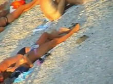 Chicas nudistas en la playa brindando el calor real bajo el sol