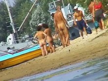 Chicas calientes desnudas en la playa del puerto deportivo