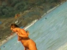 Escenas voyeur de playa nudista con aficionados bañándose en el mar