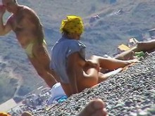 Nena pelirroja caliente toma un baño de sol desnudo en la playa