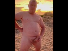Desnudo en la playa masturbándose al amanecer