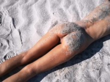 Un extraño encuentra a una morena flaca y bronceada perfecta en una playa nudista y le da una meada caliente