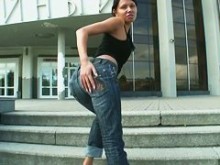 Chica de culo sexy en jeans coquetea con una cámara callejera sincera