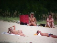 Rubia tetona en la playa nudista espiada por un voyeur