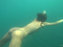 Modelo desnuda nada en una playa pública en Rusia