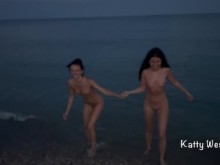 Dos zorras desnudas nadan en el mar en una playa pública