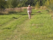 Playa nudista. Un chico al azar mira a una MILF desnuda tomando el sol sin bragas ni sujetador. Desnudo en público. naturistas
