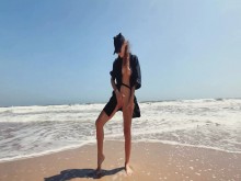 Chica adolescente metiendo los dedos en el coño afeitado en la playa nudista a la orilla del mar, en público al aire libre, mastirbación en