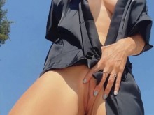 Chica adolescente desnuda muestra coño, piernas y pies y dedos de los pies, pie, fetiche de piernas en la playa nudista al aire libre
