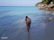 Pelirroja desnuda se baña en una playa pública