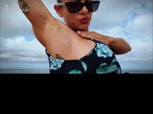 Axilares bañadas por el sol y diosa de la vena de bíceps bombeados en la playa